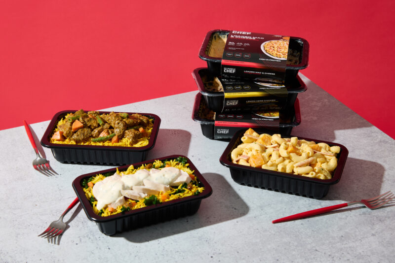 My Muscle Chef meals arranged on a table with bright red background