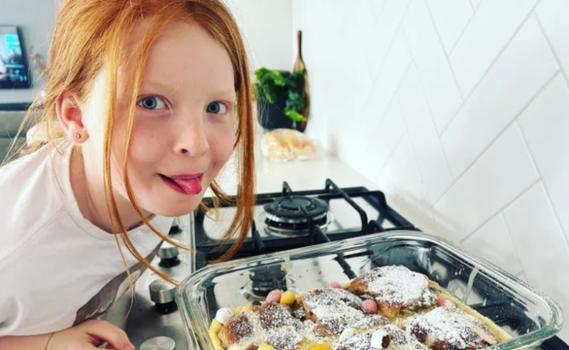 Bella Macey leaning over tray in a kitchen